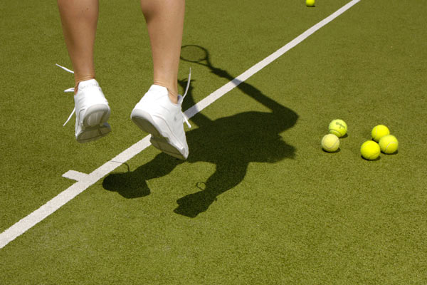 feet of tennis player serving ball by Janie Airey photographer