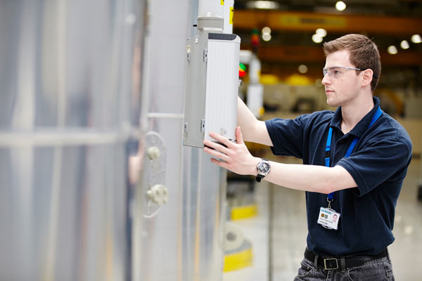young man at machine in Siemens factory by Janie Airey photographer